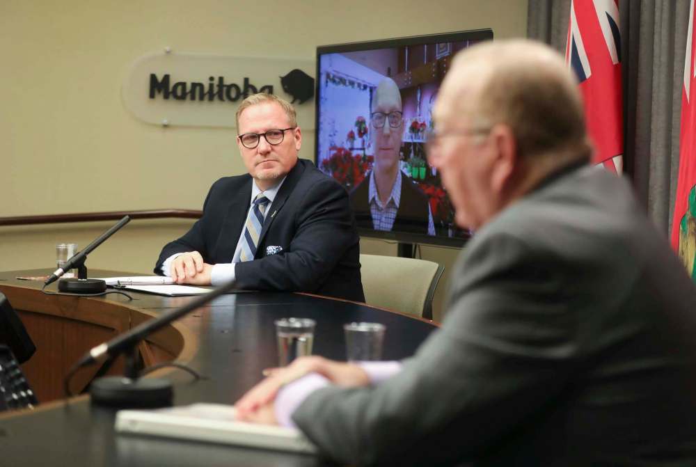 RUTH BONNEVILLE / WINNIPEG FREE PRESS
Finance Minister Scott Fielding (left), Broadway Florists co-owner Costa Cholakis (on screen) and Economic Development Minister Ralph Eichler at the announcement of the online campaign to highlight the stories of Manitoba businesses.