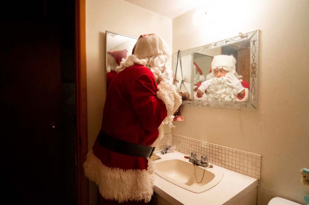 Stan Bedernjak gets his beard and hat ready to head out to spread some Christmas cheer last week.