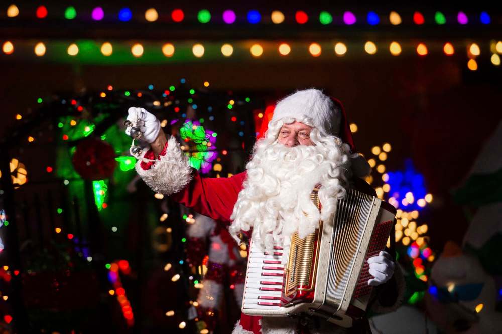 Stan Bedernjak spreads holiday cheer with his accordion in front of a brightly decorated house on Lincrest Road last week.