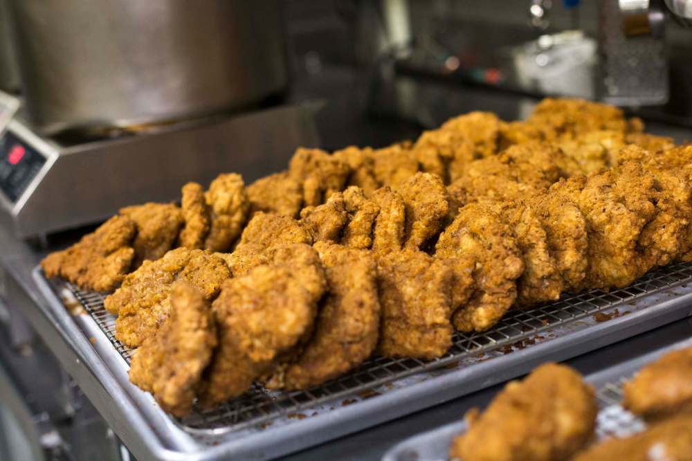 Freshly made breaded pork cutlets stand after cooking. (Mikaela MacKenzie / Winnipeg Free Press)