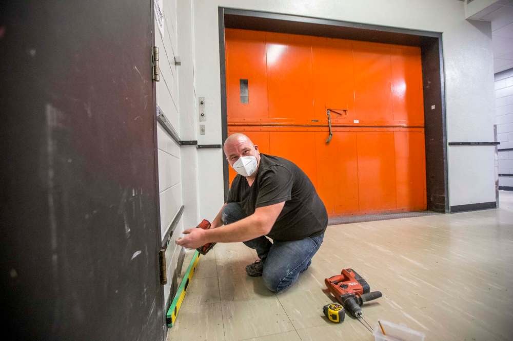 Vince Paulich, facility services supervisor, puts up bumper strips along hallway walls to protect against damage from tour cases being moved from the loading dock. (Mikaela MacKenzie / Winnipeg Free Press)