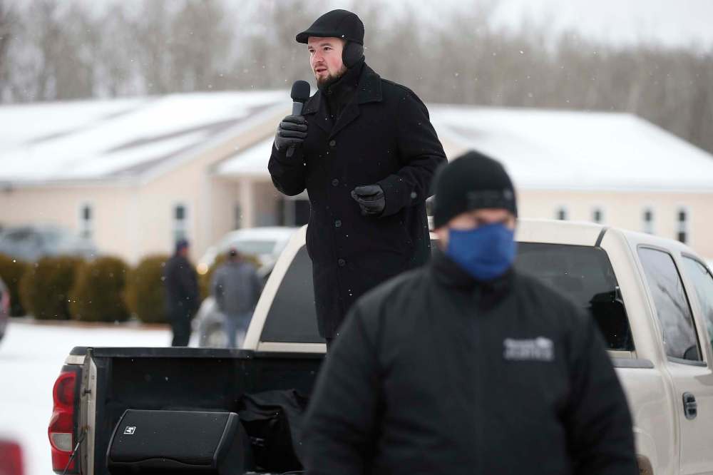 JOHN WOODS / WINNIPEG FREE PRESS Church of God Restoration pastor Tobias Tissen speaks from a truck as RCMP officers and Manitoba Justice officials blocked the entrance.