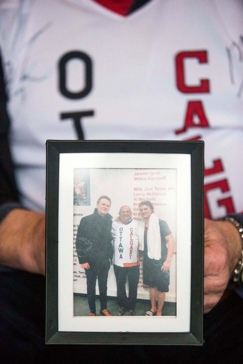 MIKAELA MACKENZIE / WINNIPEG FREE PRESS
Oster, proud Winnipeg grandpa of Matthew and Brady Tkachuk, holds a picture of the three of them.