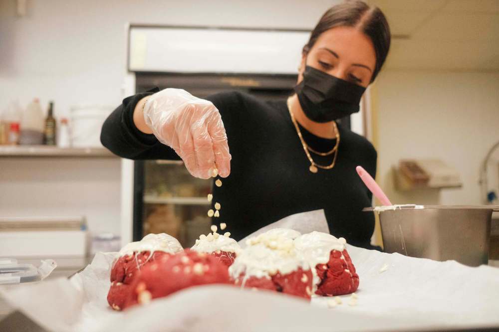 MIKE SUDOMA / WINNIPEG FREE PRESS
Reid puts the finishing touch of white chocolate chips on a batch of her Red Velvet cookies.