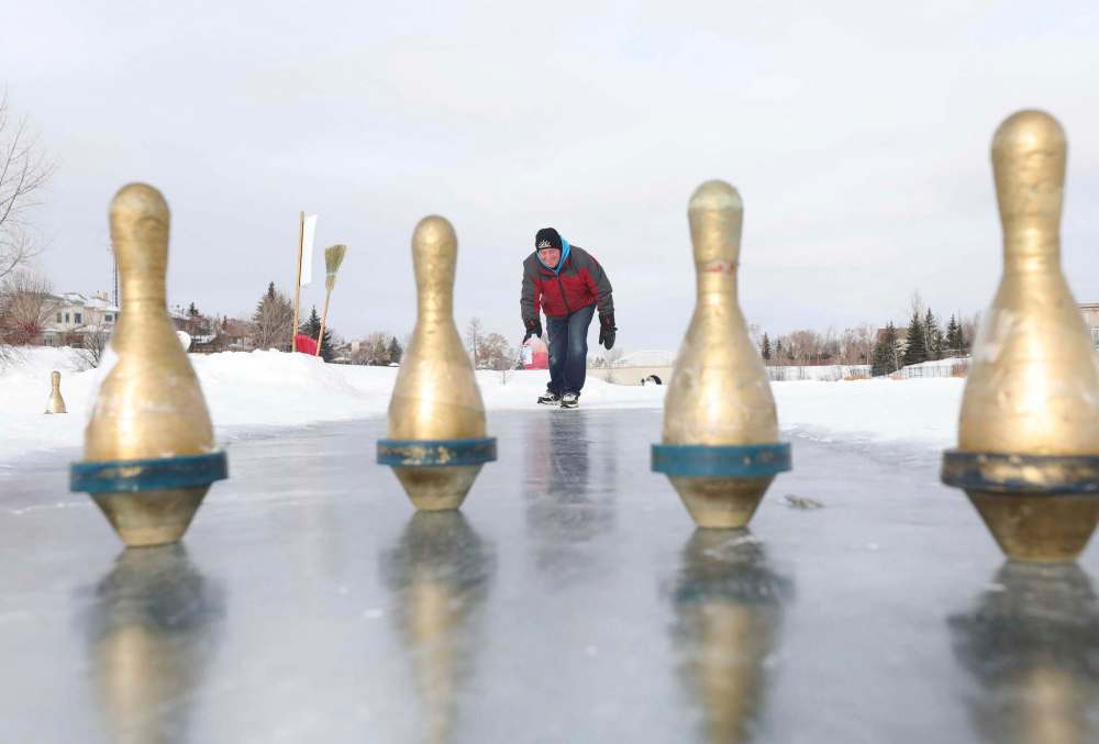 RUTH BONNEVILLE / WINNIPEG FREE PRESS
Jim Llewellyn, owner of Coronation Bowling Centre, throws a milk jug down the ice toward bowling pins. With his business closed due to pandemic restrictions, Llewellyn set up ice bowling lanes near his home in southeast Winnipeg.