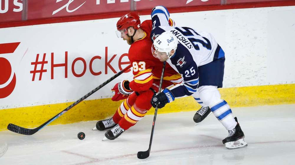 Winnipeg Jets' Paul Stastny, right, checks Calgary Flames' Sam Bennett during second period NHL hockey action in Calgary, Tuesday, Feb. 9, 2021.THE CANADIAN PRESS/Jeff McIntosh