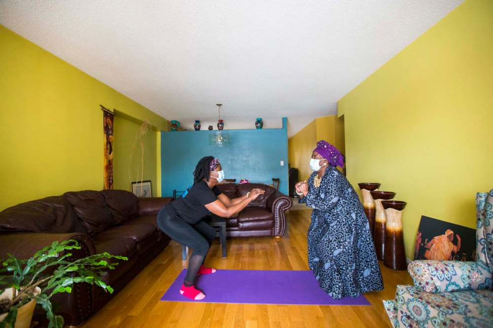 Mwaka Kaonga and her mom, Phillis Nachilongo, demonstrate the workout that Phillis has been doing since last year at the start of the lockdown at their home. (Mikaela MacKenzie / Winnipeg Free Press)