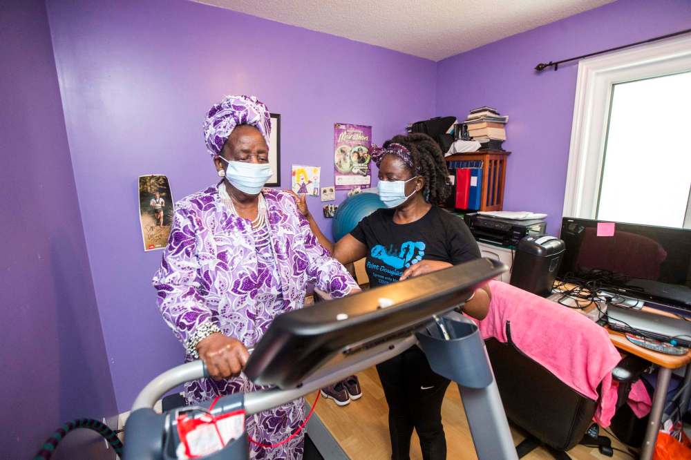 Mwaka Kaonga and her mom, Phillis Nachilongo, demonstrate the workout that Phillis has been doing since last year at the start of the lockdown at their home. (Mikaela MacKenzie / Winnipeg Free Press)