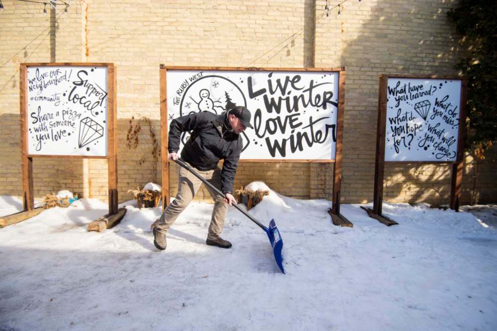 MIKE SUDOMA / WINNIPEG FREE PRESS
Jamie Hilland of the Ruby West coffee shop on Westminster cleans snow off of the spot where the café’s temporary patio sat last year.