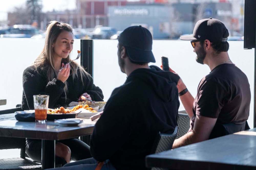 Carly Taggart (left) and friends spend time together on the patio at Fionns on Grant Avenue. (Daniel Crump / Winnipeg Free Press)