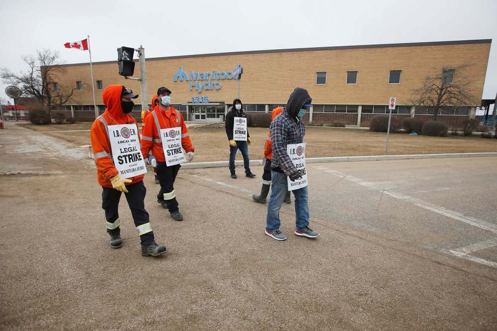 Manitoba Hydro workers walk the picket line in Winnipeg on Tuesday. The 2,300 members of the International Brotherhood of Electrical Workers Local 2034 rejected the corporation's final offer. (John Woods / Winnipeg Free Press)