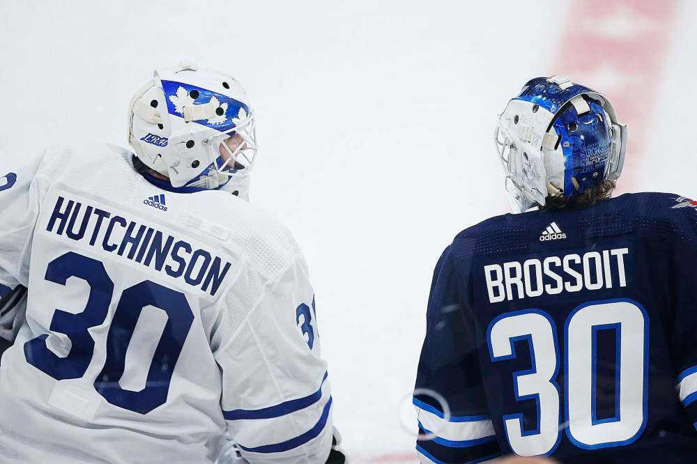 John Woods / The Canadian Press
Hutchinson chats with Jets goaltender Laurent Brossoit during warm up Wednesday.