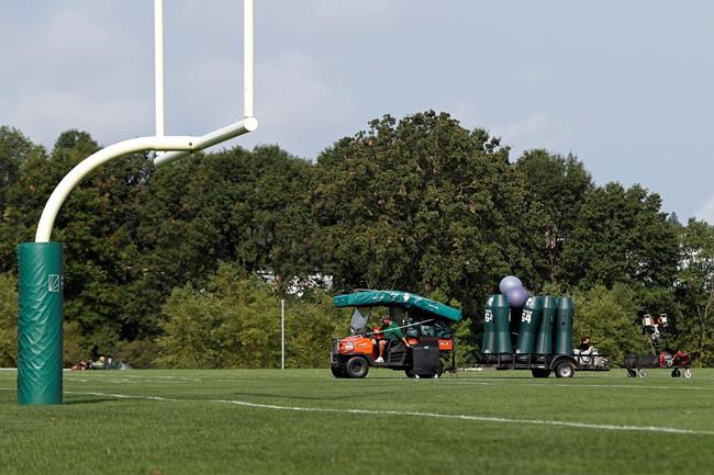 New York Jets personnel clear practice equipment after practice was canceled at the NFL football team's training camp in Florham Park, N.J., Thursday, Aug. 27, 2020. The New York Jets canceled their practice in an apparent response to the shooting of Jacob Blake, a Black man, in Wisconsin. The Jets provided no immediate details on their decision to not practice. (AP Photo/Adam Hunger)