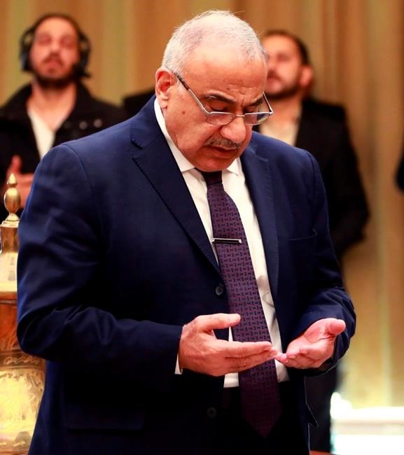 A photo released by the Iraqi Prime Minister Media Office shows Iraqi acting Prime Minister Adil Abdul-Mahdi, praying at a condolence ceremony for Abu Mahdi al-Muhandis, deputy commander of Iran-backed militias in Iraq known as the Popular Mobilization Forces, at the prime minister's office in Baghdad, Iraq, Monday, Jan. 6, 2020. (Iraqi Prime Minister Media Office, via AP)