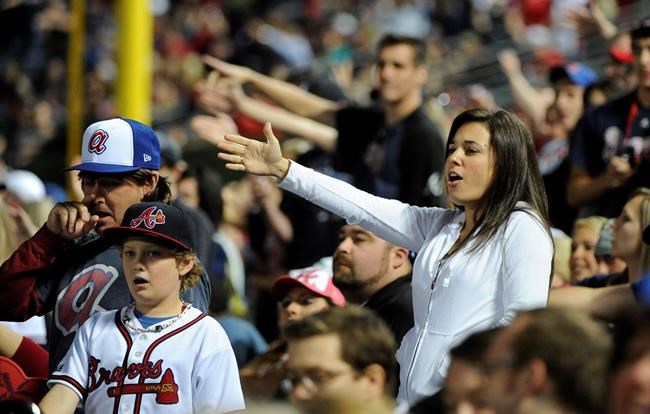 FILE - In this May 2, 2014, file photo, Atlanta Braves fans do the tomahawk chop during the ninth inning of a baseball game with the San Francisco Giants, in Atlanta. The Atlanta Braves say they have no plans to follow the lead of the NFL's Washington Redskins and change their team name. The team said in a letter to season ticket holders they are examining the fan experience, including the tomahawk chop chant, and have formed a