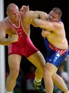 FILE - In this Sept. 27, 2000, file photo, Rulon Gardner, right, of the United States, holds the arm of Aleksandr Karelin, of Russia, during the final bout in the 130kg class of Greco-Roman wrestling event at the Summer Olympic Games in Sydney. An Olympic Channel documentary debuting Wednesday, July 22, 2020, chronicles the highs and lows of Rulon Gardner in the 20 years since his stunning gold-medal victory in the 2000 Olympics. (AP Photo/Katsumi Kasahara, File)