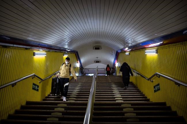 FILE - In this Feb. 3, 2020, file photo, people wearing face masks walk through a normally busy subway station during the morning rush hour in Beijing. Health authorities are preparing for a possible pandemic as they work to contain a respiratory illness in China that's caused by a new virus. Governments are working to contain the virus by limiting travel, isolating sick people and keeping travelers returning from the affected region under quarantine to watch for symptoms. (AP Photo/Mark Schiefelbein, File)