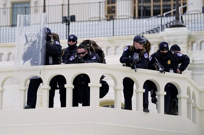 Police keep a watch on demonstrators who tried to break through a police barrier, Wednesday, Jan. 6, 2021, at the Capitol in Washington. (AP Photo/Julio Cortez)