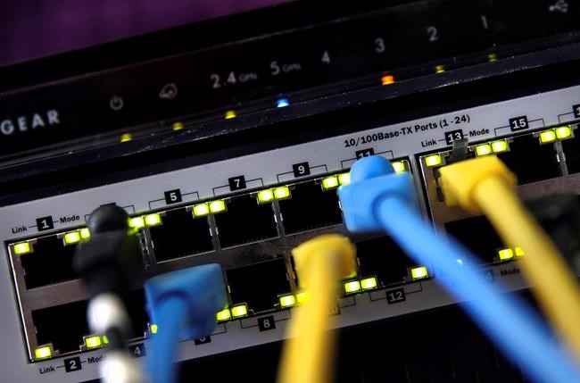 FILE - In this June 19, 2018, file photo, a router and internet switch are displayed in East Derry, N.H. With so much of the U.S. workforce, and their families, now cooped up at home to combat the spread of coronavirus, it's not a huge surprise that home internet is showing the strain. Will there be a bandwidth problem with all the devices going at once? (AP Photo/Charles Krupa, File)
