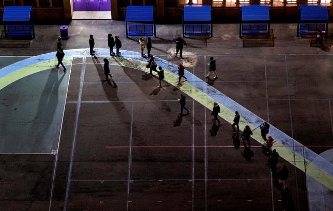 People line up on a playground before the door of a polling place opened at an elementary school in the Manhattan borough in New York Tuesday, Nov. 3, 2020. (AP Photo/Craig Ruttle)