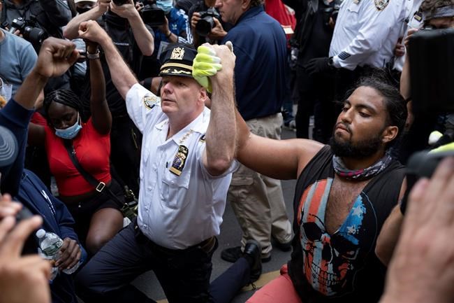 Chief of Department of the New York City Police, Terence Monahan, takes a knee with activists as protesters paused while walking in New York, Monday, June 1, 2020. Demonstrators took to the streets of New York to protest the death of George Floyd, who died May 25 after he was pinned at the neck by a Minneapolis police officer. (AP Photo/Craig Ruttle)