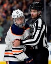 FILE - In this Feb. 15, 2018, file photo, Edmonton Oilers center Drake Caggiula is held by linesman Brandon Gawryletz during the third period of the Oilers' NHL hockey game against the Vegas Golden Knights in Las Vegas. Because NHL players are expected to be tested daily, there isn’t expected to be additional on-ice equipment required for practices and games. Deputy Commissioner Bill Daly additionally said he didn't anticipate any mandatory equipment changes to ensure player safety. Still, hockey equipment manufacturer Bauer has spoken with the league and teams about medical-grade off-ice visors that coaches, executives, team personnel and others could wear as a measure of protection against spreading or contracting COVID-19. (AP Photo/David Becker, File)