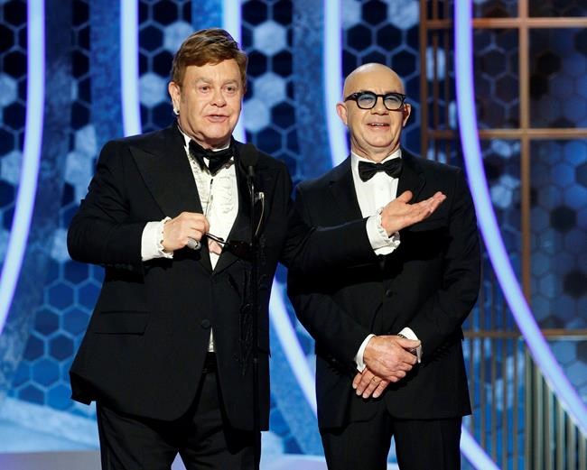 This image released by NBC shows presenters Elton John, left, and Bernie Taupin at the 77th Annual Golden Globe Awards at the Beverly Hilton Hotel in Beverly Hills, Calif., on Sunday, Jan. 5, 2020. (Paul Drinkwater/NBC via AP)
