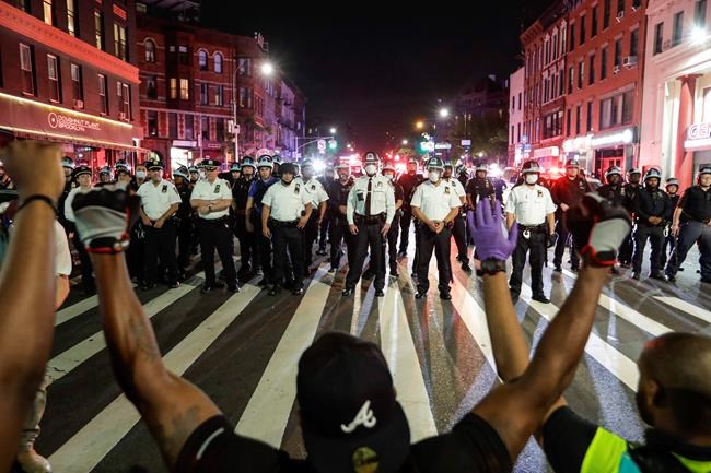 Protesters take a knee on Flatbush Avenue in front of New York City police officers during a solidarity rally for George Floyd, Thursday, June 4, 2020, in the Brooklyn borough of New York. Floyd died after being restrained by Minneapolis police officers on May 25. (AP Photo/Frank Franklin II)