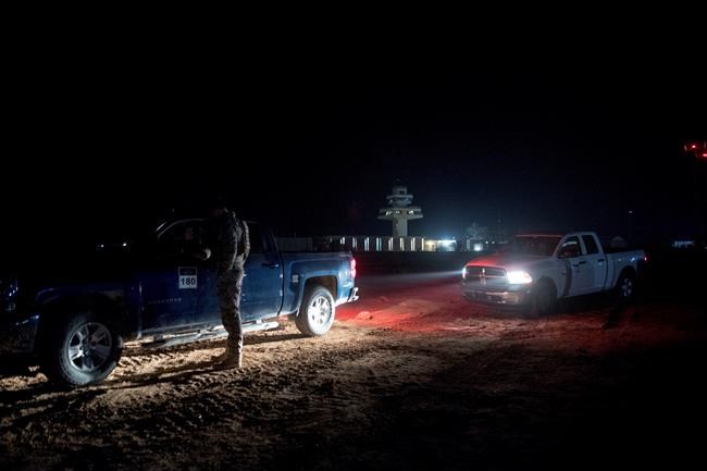 FILE - In this Dec. 26, 2018, file photo, members of the military wait outside facilities where President Donald Trump and first lady Melania Trump are visiting at Al Assad Air Base, Iraq. Iran said Wednesday, Jan. 8, 2020, it has launched