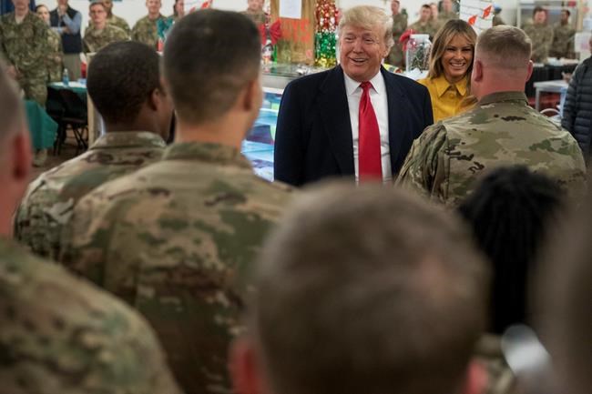 FILE - President Donald Trump and first lady Melania Trump visit with members of the military at a dining hall at Al Assad Air Base, Iraq. Iran said Wednesday, Jan. 8, 2020, it has launched