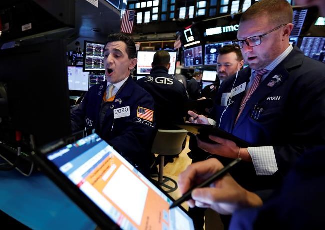 FILE - In this Feb. 24, 2020, file photo specialist Peter Mazza, left, works with traders at his post on the floor of the New York Stock Exchange. The U.S. stock market opens at 9:30 a.m. EST on Friday, Feb. 28. (AP Photo/Richard Drew, File)