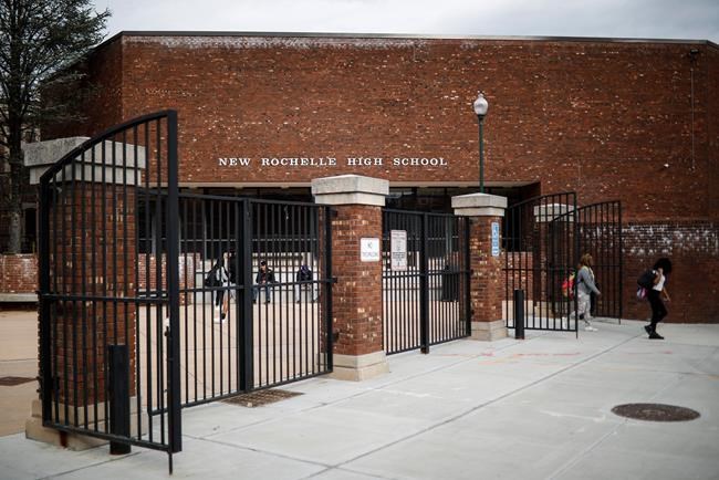 Students leave New Rochelle High School after classes are dismissed, Tuesday, March 10, 2020, in New York. State officials are shuttering schools and houses of worship for two weeks in part of the New York City suburb New Rochelle and sending the National Guard there to help respond to what appears to be the nation's biggest cluster of coronavirus cases. (AP Photo/John Minchillo)