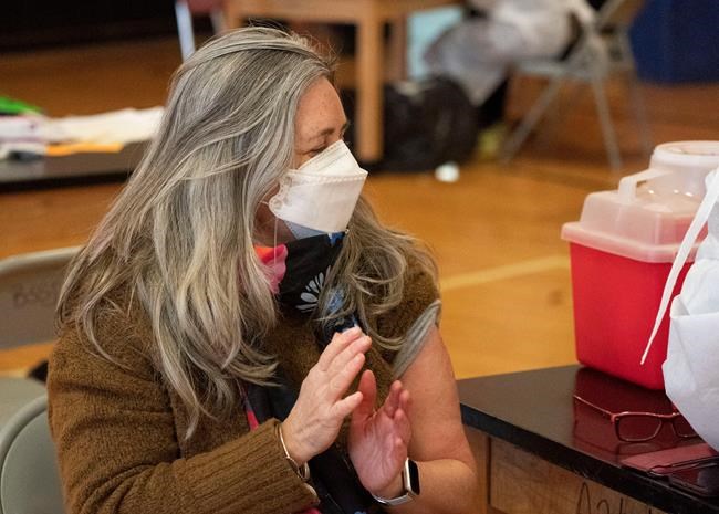 Teacher Lisa Egan claps after she receives the Moderna coronavirus vaccine at a clinic organized by New York City's Department of Health, Monday, Jan. 11, 2021.