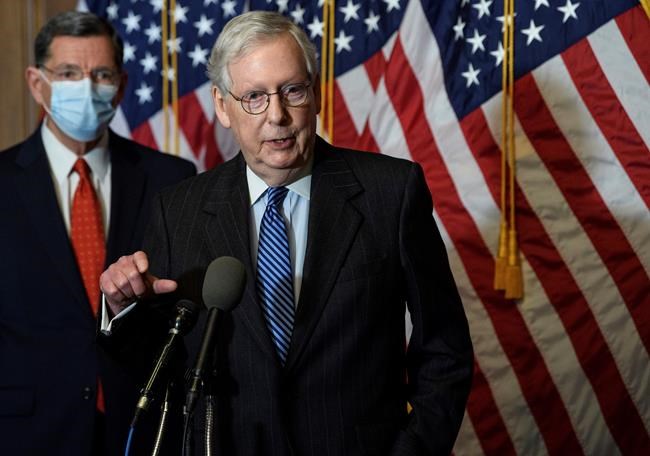 FILE - In this Tuesday, Dec. 15, 2020, file photo, Senate Majority Leader Mitch McConnell, of Kentucky, speaks during a news conference with other Senate Republicans on Capitol Hill in Washington, while Sen. John Barrasso, R-Wyoming, listens at left. Congress is preparing to convene for a new session with lawmakers sworn into office during a tumultuous period. Opening the Senate could be among Mitch McConnell’s final acts at majority leader. Republican control is in question until Tuesday’s runoff elections for two Senate seats in Georgia. The outcome will determine which party holds the chamber. (Nicholas Kamm/Pool Photo via AP, File)