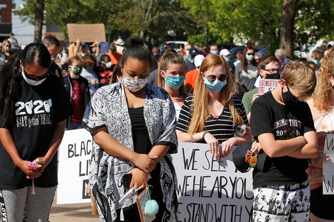 People bow their heads during a prayer at a rally, Wednesday, June 3, 2020, in Stillwater, Okla., to protest the death of George Floyd, a black man who died after being restrained by Minneapolis police officers on May 25. (AP Photo/Sue Ogrocki)