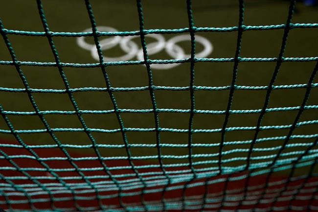 The Olympic rings painted on the field are seen through a net as U.S. softball players take batting practice at the Fukushima Azuma Baseball Stadium ahead of the 2020 Summer Olympics, Tuesday, July 20, 2021, in Fukushima, Japan. (AP Photo/Jae C. Hong)
