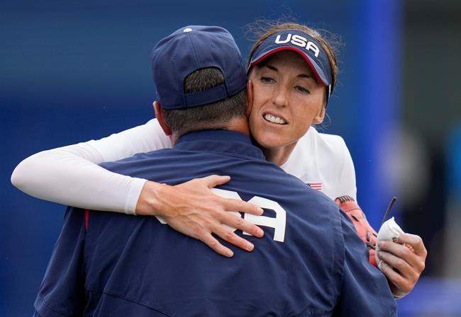 United States head coach Ken Eriksen embraces Monica Abbott after defeating Canada in their softball game at the 2020 Summer Olympics, Thursday, July 22, 2021, in Fukushima , Japan. (AP Photo/Jae C. Hong)