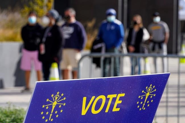 Voters wait in line to cast their ballot in the 2020 Presidential election during early voting in Noblesville, Ind., Wednesday, Oct. 14, 2020. (AP Photo/Michael Conroy, File)
