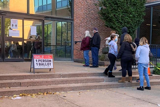 Voters wait in line outside the Bucks county government building in Doylestown, Pa., a suburb of Philadelphia, on Monday, Nov. 2, 2020. Some said they received word that their mail-in ballots had problems and needed to be fixed in order to count. (AP Photo/Mike Catalini)