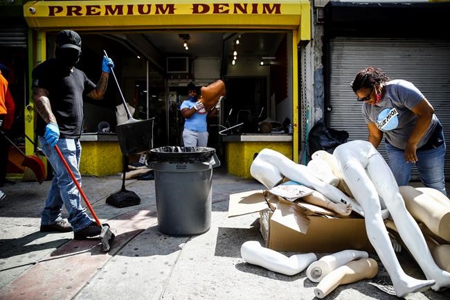 Volunteer community members clean up a looted store in Philadelphia, Monday, June 1, 2020 in the aftermath of protest and unrest in reaction to George Floyd's death while in police custody on May 25 in Minneapolis. (AP Photo/Matt Rourke)