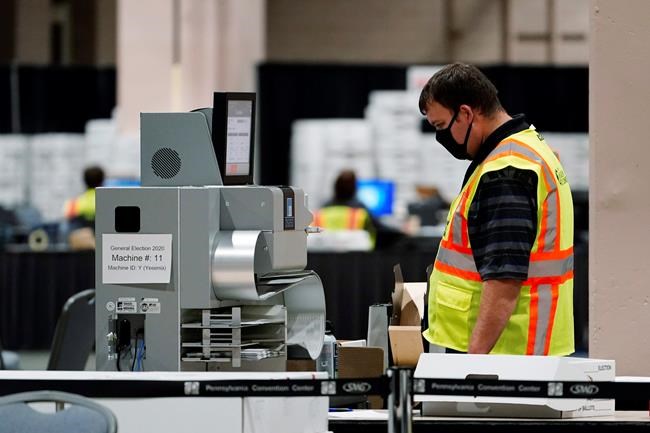 A Philadelphia election worker scans ballots for the 2020 general election in the United States at the Pennsylvania Convention Center, Tuesday, Nov. 3, 2020, in Philadelphia. (AP Photo/Matt Slocum)