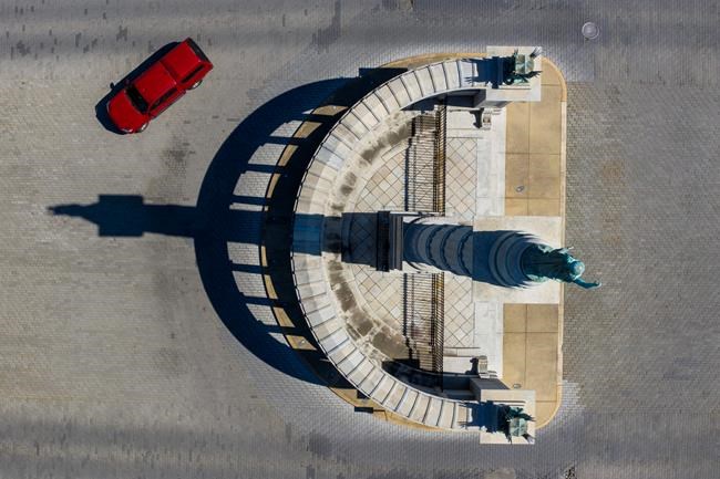 FILE this Tuesday April 7, 2020 file photo shows space traffic winds around the statue of Confederate President Jefferson Davis on Monument Ave in Richmond, Va. Virginia Gov. Ralph Northam is expected to announce plans Thursday for the removal of an iconic statue of Confederate Gen. Robert E. Lee from Richmond's prominent Monument Avenue. Richmond Mayor Levar Stoney proposes taking down all the Confederate Monuments. (AP Photo/Steve Helber, file)