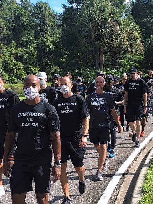 NBA referees march in support of players seeking an end to racial injustice in Lake Buena Vista, Fla., Thursday, Aug. 27, 2020. Their march came shortly before players met to decide on restarting the season after three games were postponed Wednesday. (AP Photo/Brian Mahoney)