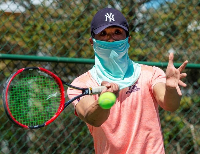 Young Park returns a shot while playing tennis Wednesday May 20, 2020 in Montreal. The Quebec government has lifted restrictions on several leiaure activities imposed due to the COVID-19 pandemic.THE CANADIAN PRESS/Ryan Remiorz