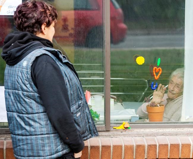 Annette Demeny, left, visits through the window with her friend Concetta Lamberto at the Vigi Mount Royal seniors residence Friday May 1, 2020 in Montreal North. The area has been identified as one of the hardest hit with COVID-19 on the island. THE CANADIAN PRESS/Ryan Remiorz