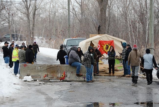 People gather at a protest in Kahnawake, Que. on Tuesday, Feb. 25, 2020, in solidarity with Wet'suwet'en Nation hereditary chiefs attempting to halt construction of a natural gas pipeline on their traditional territories. THE CANADIAN PRESS/Ryan Remiorz