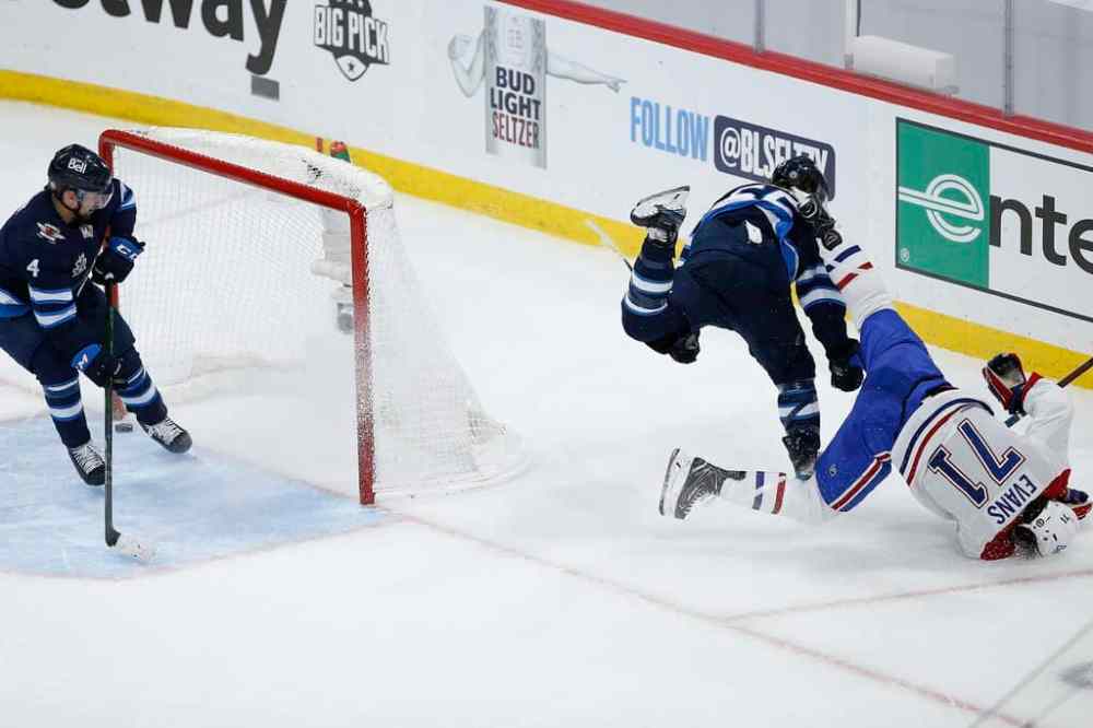 CP
Montreal Canadiens' Jake Evans crumples to the ice after being hit by Winnipeg Jets' Mark Scheifele Wednesday in Winnipeg. THE CANADIAN PRESS/John Woods