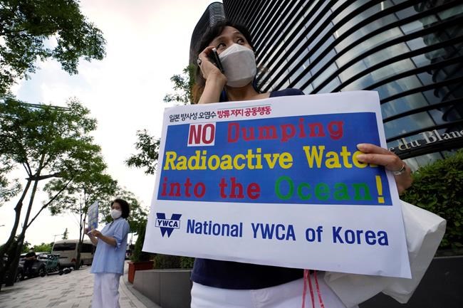 Members of the National YWCA of Korea stand to oppose South Korean President Moon Jae-in's possible visit to Japan, in front of a building which houses Japanese embassy in Seoul, South Korea, Monday, July 19, 2021. Moon has decided not to visit Japan for the Tokyo Summer Olympics, citing a failure to set up a summit with Japan's prime minister that would produce meaningful results in improving relations.(AP Photo/Ahn Young-joon)