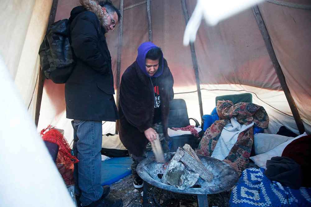 JOHN WOODS / WINNIPEG FREE PRESS
Jenna Wirch, right, and a group of volunteers from the harm reduction and Indigenous communities have raised a teepee with a fire pit at the homeless camp at the corner of Austin Street and Henry Avenue so homeless people who aren’t able to access nearby shelters can stay warm through the winter.