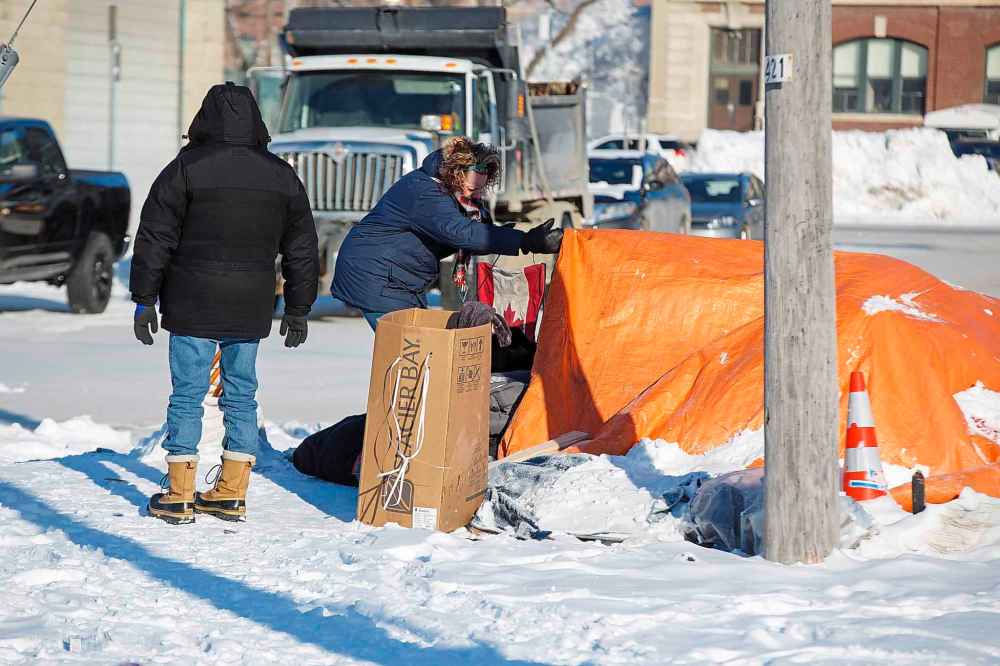 MIKE DEAL / WINNIPEG FREE PRESS
Adrienne Duduk, director of housing at the Main Street Project checks on Darren Flett's tent, helping him move to a friends tent so that the city can start cleaning up the site Thursday morning.